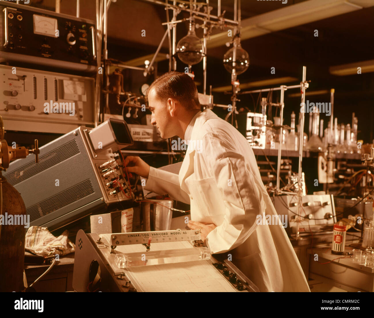 1960 1960S WISSENSCHAFTLER LABORANTIN IN BILDSCHIRM OSZILLOSKOP WISSENSCHAFT TECHNOLOGIE WISSENSCHAFTLER LABS RETRO Stockfoto