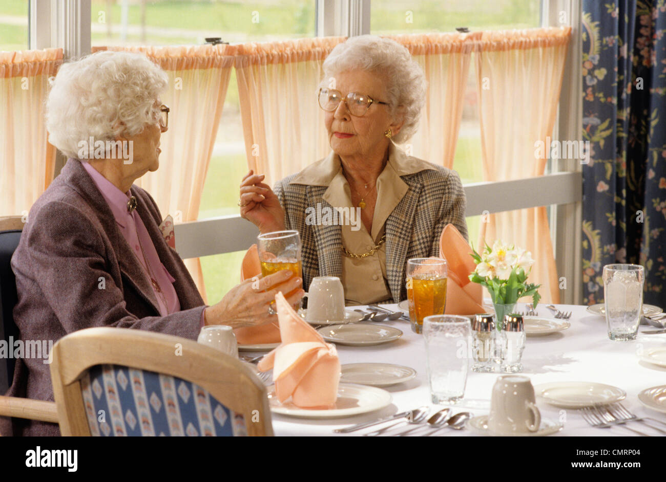 ZWEI ÄLTERE FRAUEN REDEN, SITZEN IM SPEISESAAL DES RESTAURANTS Stockfoto