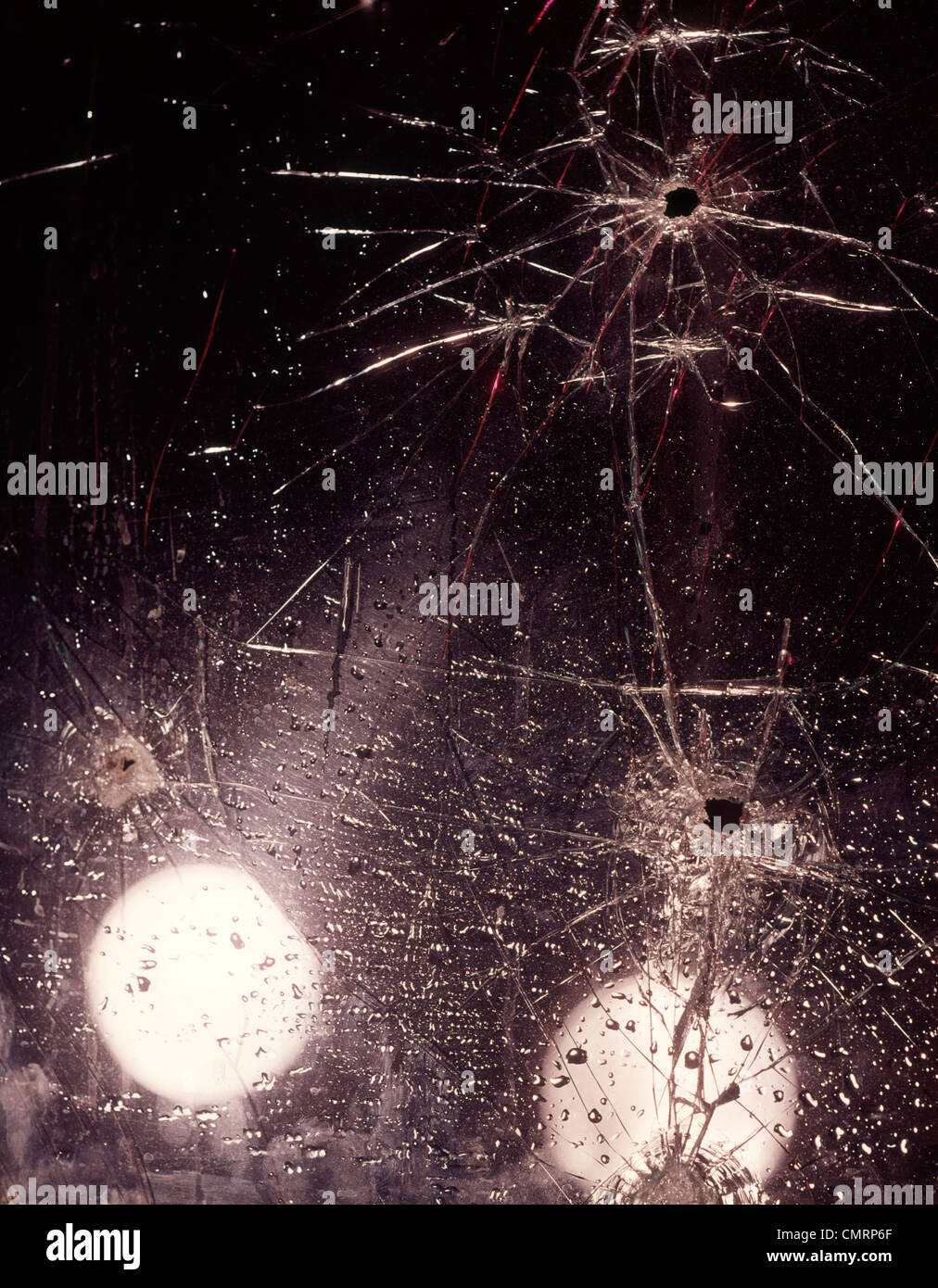 EINSCHUSSLÖCHER UND REGENTROPFEN AUF ZERBROCHENE GLAS WINDSCHUTZSCHEIBE UNFALL VERBRECHEN Stockfoto