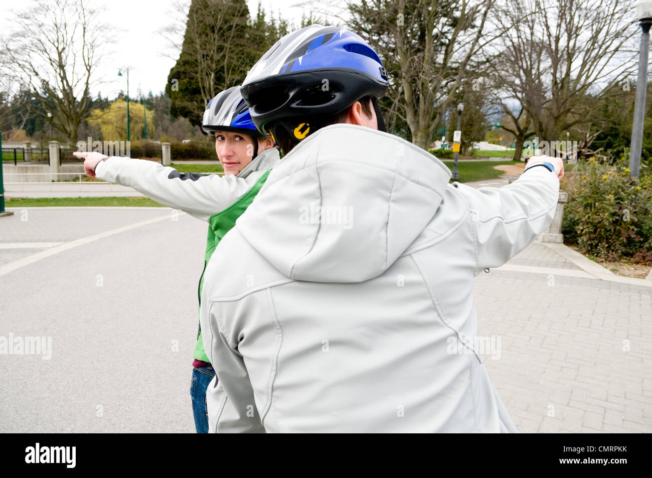 Paar mit Tandem Fahrrad zeigen in verschiedene Richtungen, Vancouver, British Columbia Stockfoto