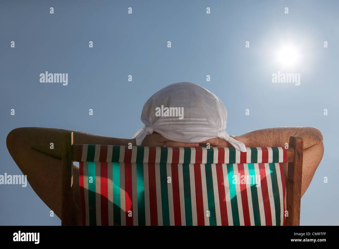 Mann ein Sonnenbad im Liegestuhl mit Taschentuch Hut auf dem Kopf Stockfoto