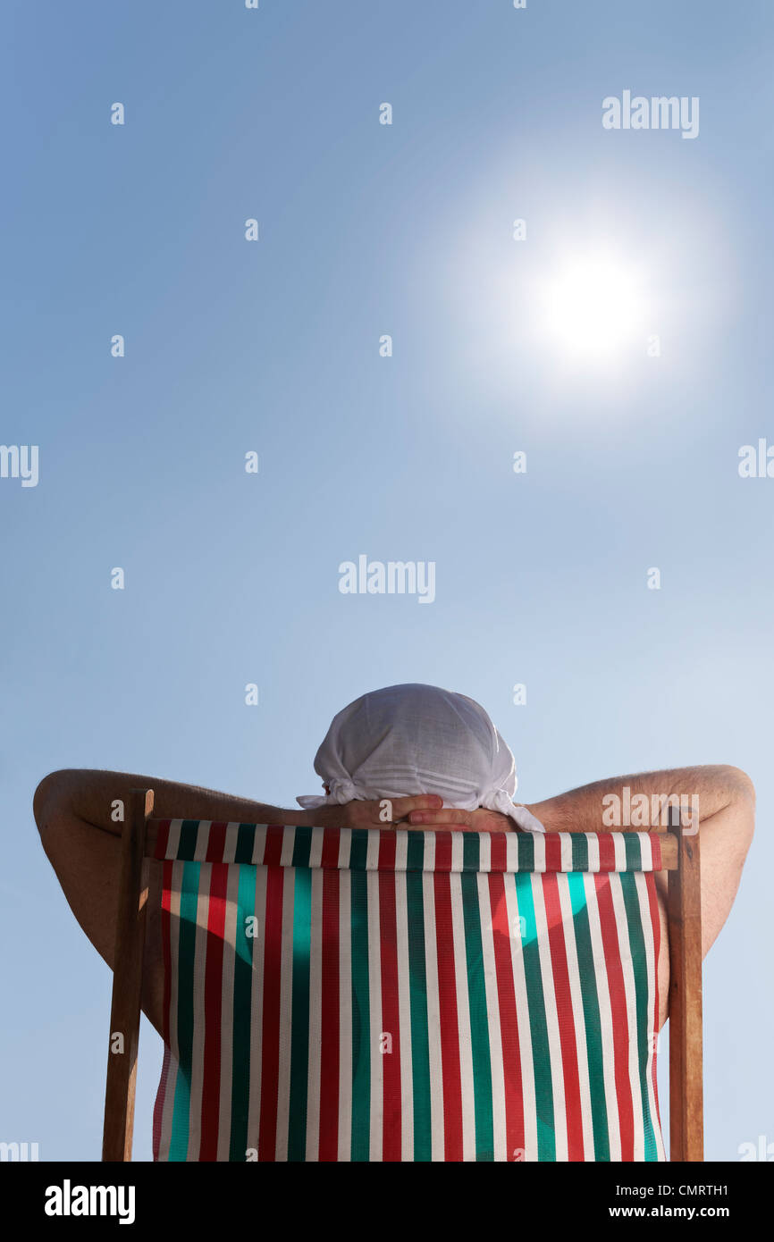 Mann ein Sonnenbad im Liegestuhl mit Taschentuch Hut auf dem Kopf Stockfoto
