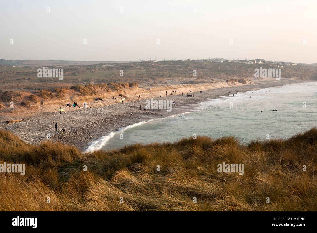 Sonnenanbeter und Surfer am Strand von Godrevy, St Ives Bay, Cornwall am Ende des Tages. Stockfoto