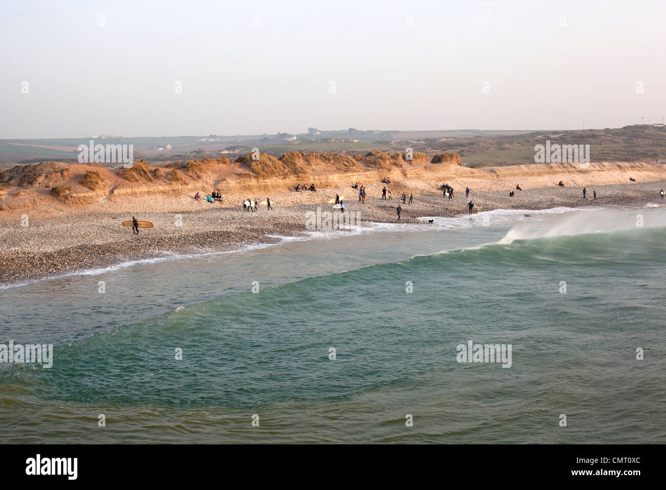 Sonnenanbeter und Surfer am Strand von Godrevy, St Ives Bay, Cornwall am Ende des Tages. Stockfoto