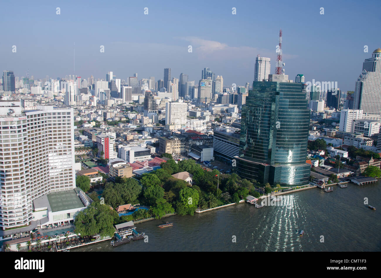 Thailand, Bangkok. Downtown Skyline von Bangkok mit Blick auf den Fluss Chao Phraya. Gebäude Fenster Reflexion auf dem Fluss. Stockfoto