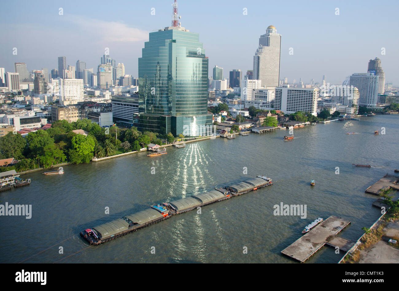 Thailand, Bangkok. Downtown Skyline von Bangkok mit Blick auf den Fluss Chao Phraya. Gebäude Fenster Reflexion auf dem Fluss. Stockfoto