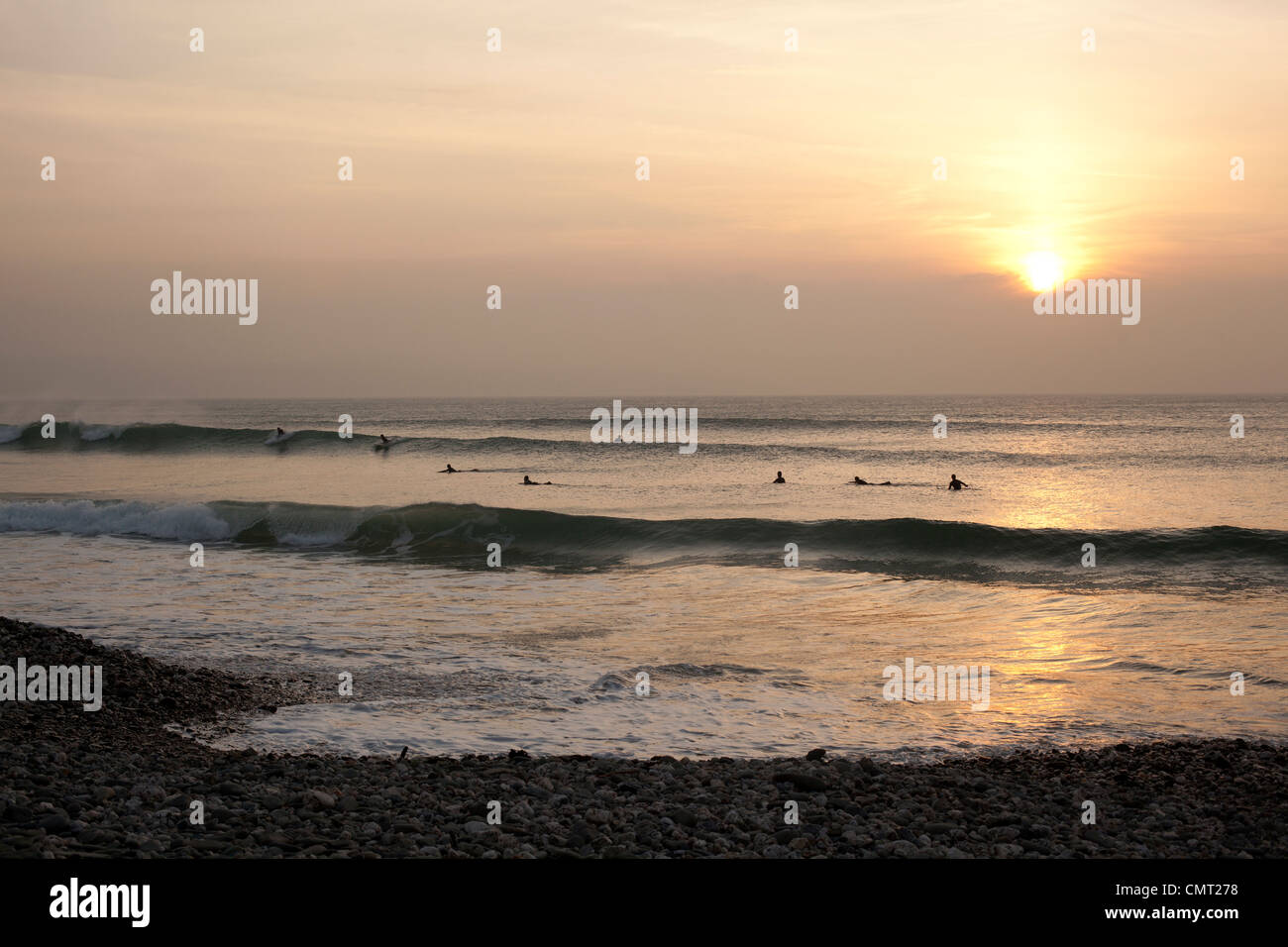 Surfer bei Sonnenuntergang im Meer am Strand, St Ives Bay, Cornwall Godrevy punktiert. Stockfoto