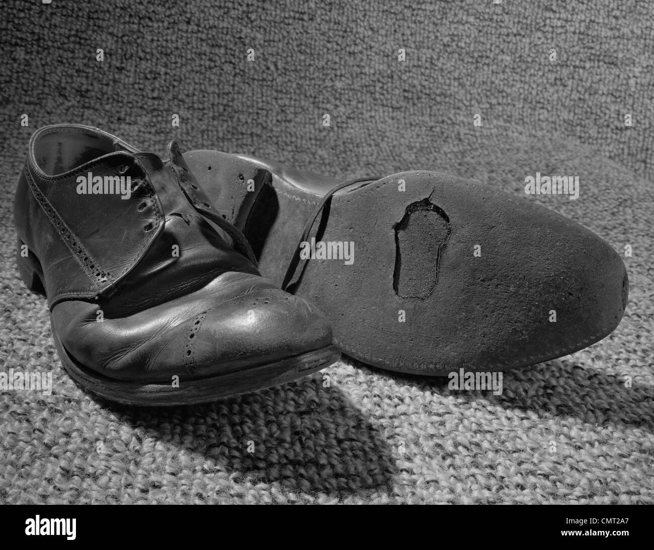 1960ER JAHRE ALTEN SCHUHE AUCH MIT LOCH IN DER SOHLE GETRAGEN Stockfoto