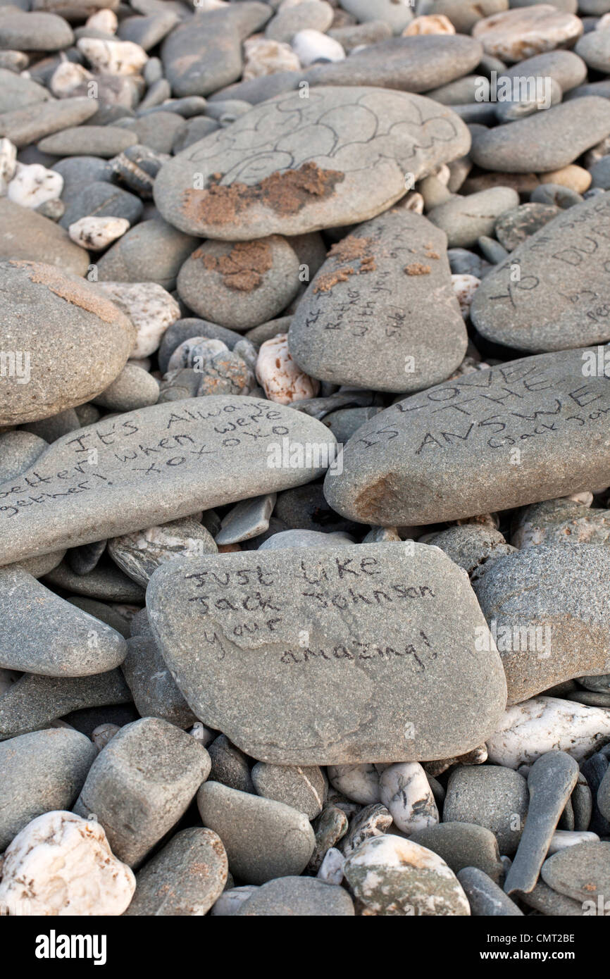 Kieselsteine am Strand bei Gwithian, Cornwall mit schriftlichen Nachrichten. Stockfoto