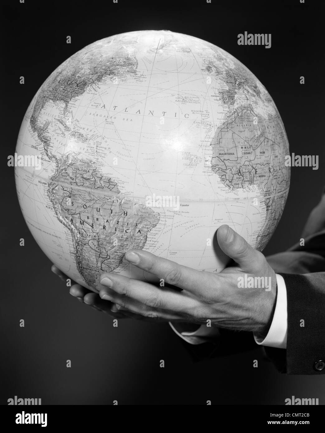 1960ER JAHREN MANS HAND HÄLT GLOBUS DER WELT Stockfoto