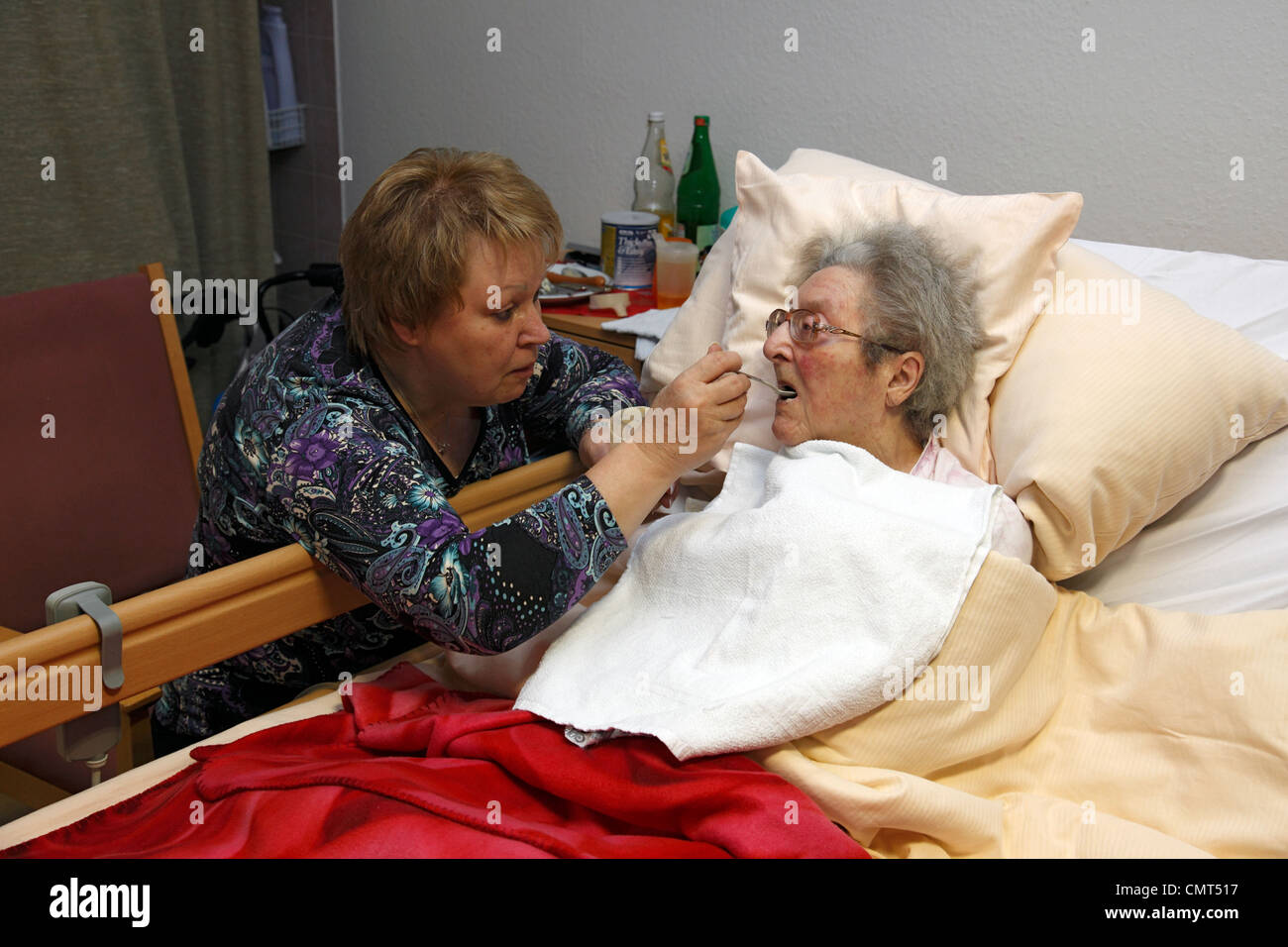 Menschen, Alter, Altersheim, Altenzentrum der St. Clemens-Hospitale in Sterkrade, ältere Frau liegt in einem Krankenbett, im Alter von 70 bis 85 Jahren, körperlicher oder geistiger Behinderung, Demenz-Erkrankung, Krankenschwester füttert sie, im Alter von 50 bis 60 Jahre, Waltraut, Elke, D-Oberhausen, Ruhrgebiet, Stockfoto