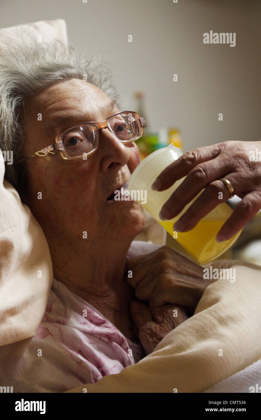 Menschen, Alter, Altersheim, Altenzentrum der St. Clemens-Hospitale in Sterkrade, ältere Frau liegt in einem Krankenbett, im Alter von 70 bis 85 Jahren, körperlicher oder geistiger Behinderung, Demenz-Erkrankung, Krankenschwester hält eine Fütterung Tasse und hilft ihr zu trinken, Waltraut, Elke, D-Oberhausen, Stockfoto