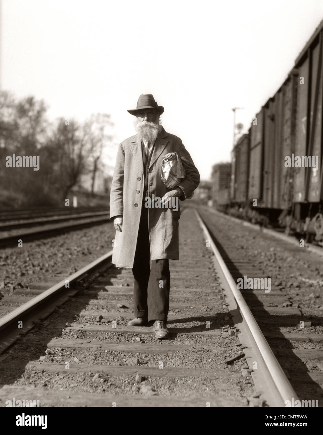 1930ER JAHREN WELTWIRTSCHAFTSKRISE ÄRA MANN OBDACHLOSER HOBO ENTLANG EISENBAHNSCHIENEN Stockfoto