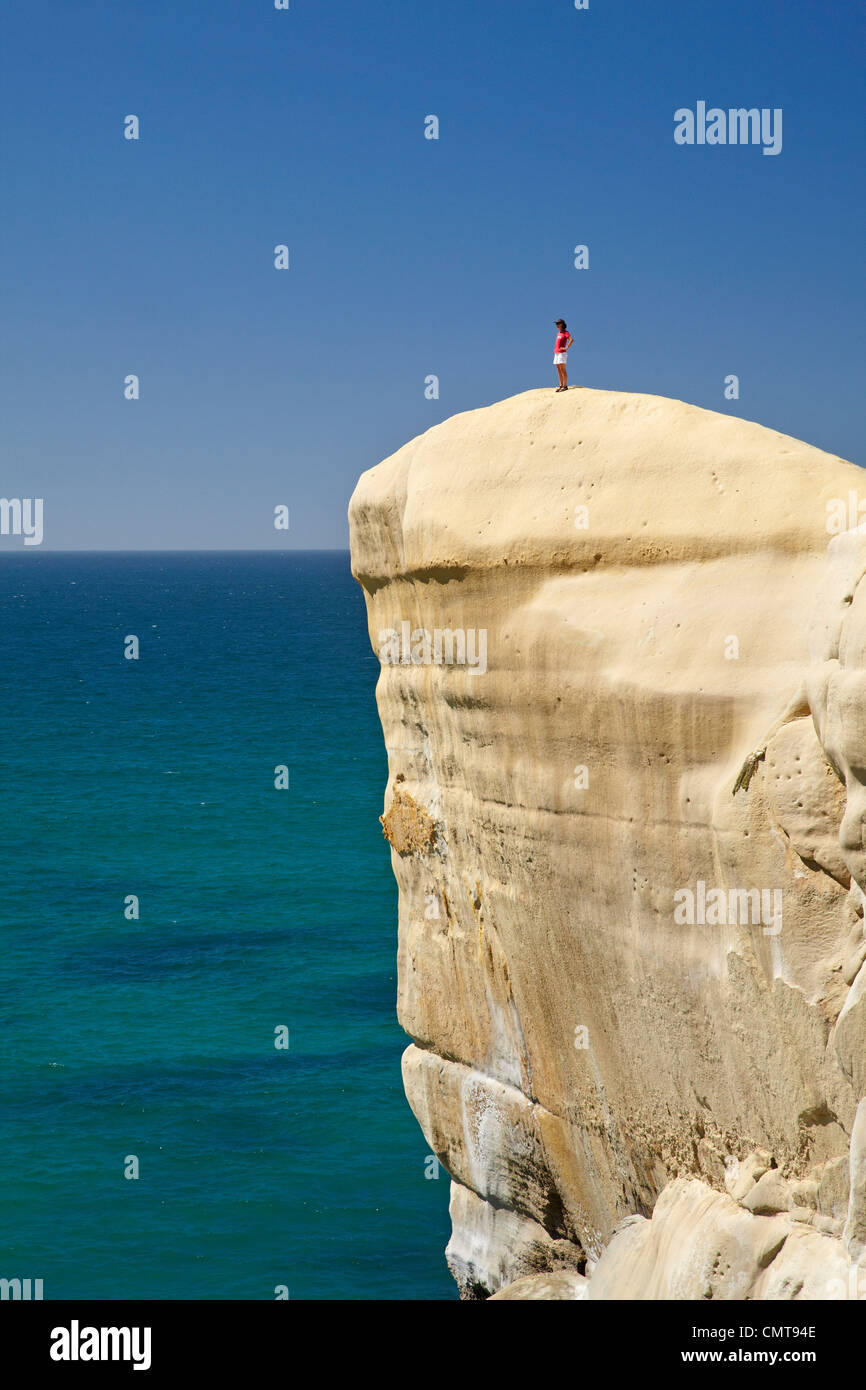 Touristen auf Klippe am Tunnel Beach, Dunedin, Südinsel, Neuseeland Stockfoto