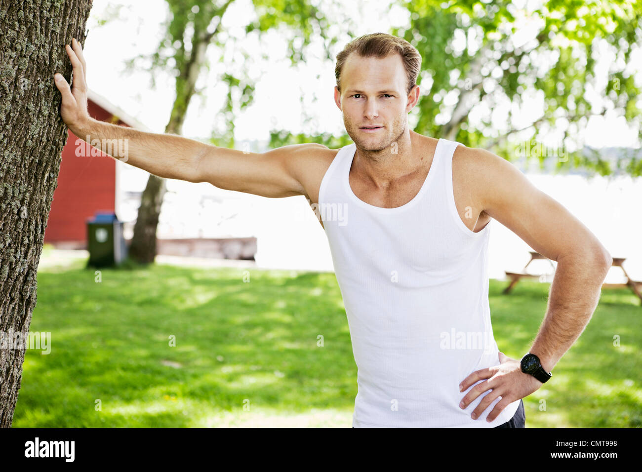 Mann an Baum gelehnt Stockfoto
