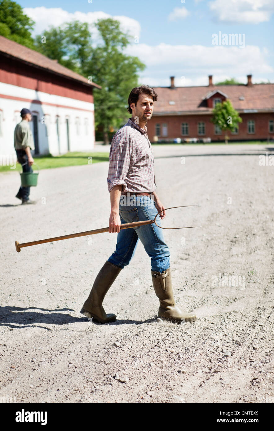 Mann mit Heugabel auf Hof Stockfoto