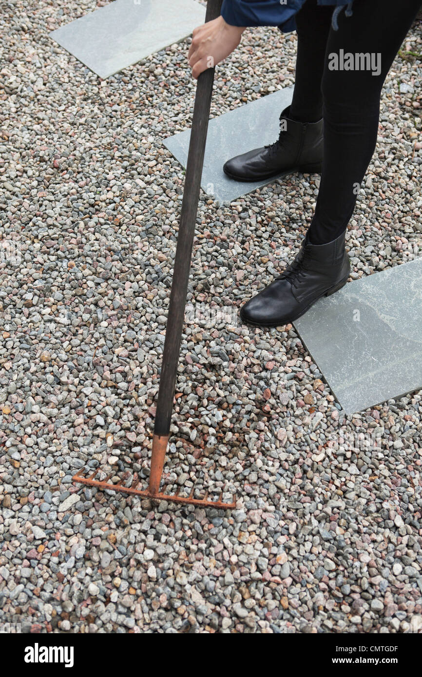 Erhöhte Ansicht von Frau Rechen Kies Stockfoto