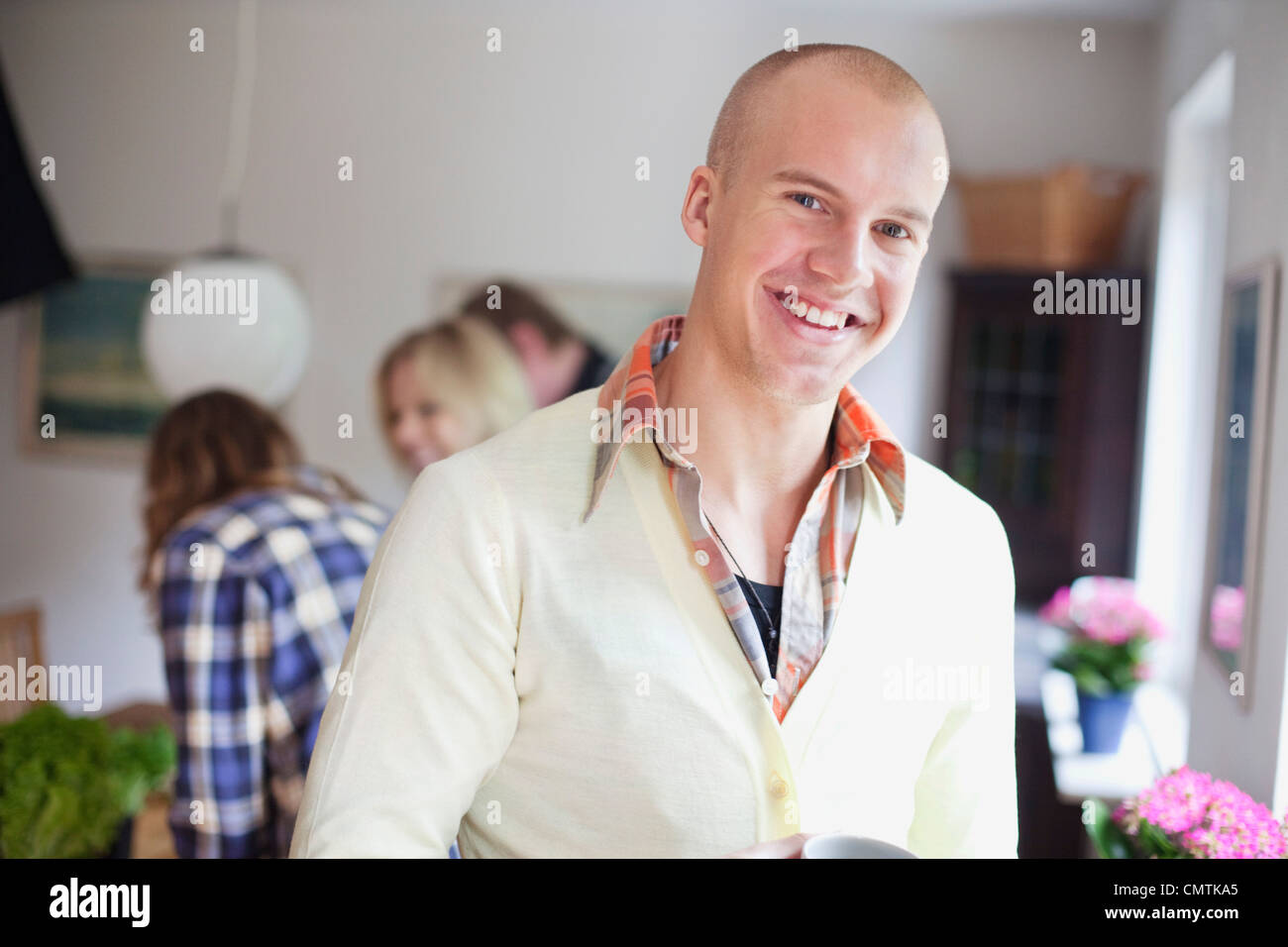 Lächelnder Mann mit Menschen im Hintergrund Stockfoto