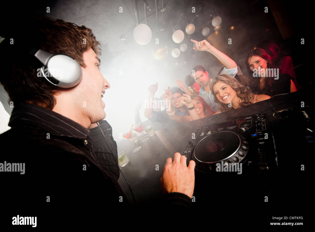 DJ spielt Musik für Publikum in Nachtclub Stockfoto