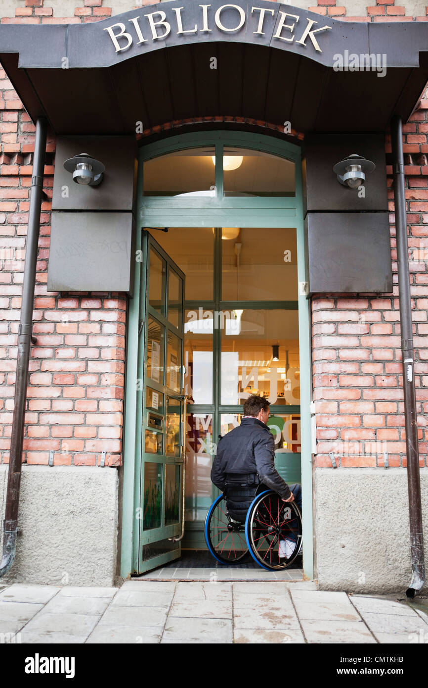 Mann im Rollstuhl, gehen in die Bibliothek Stockfoto