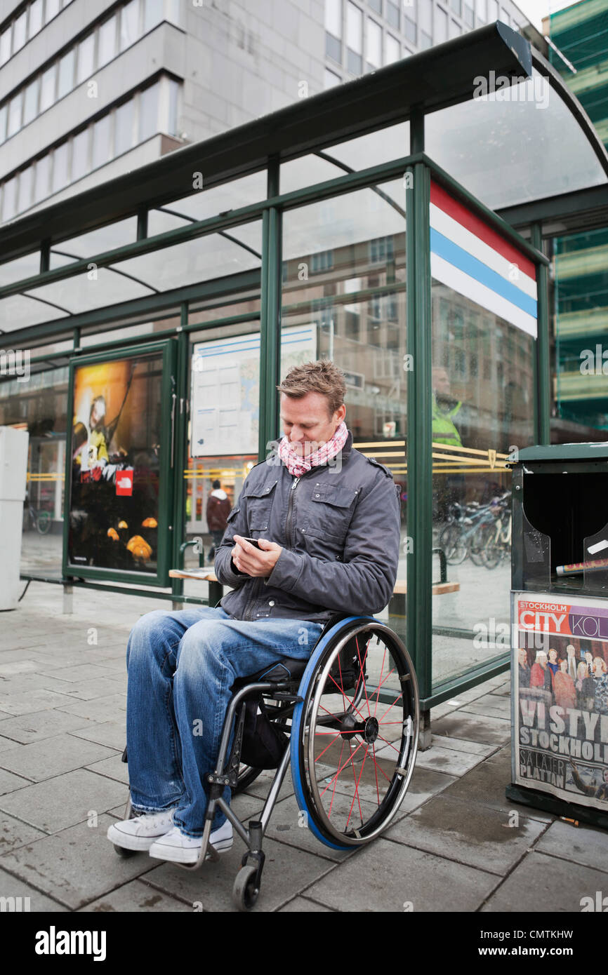Mann im Rollstuhl, die Wartezeit auf den bus Stockfoto