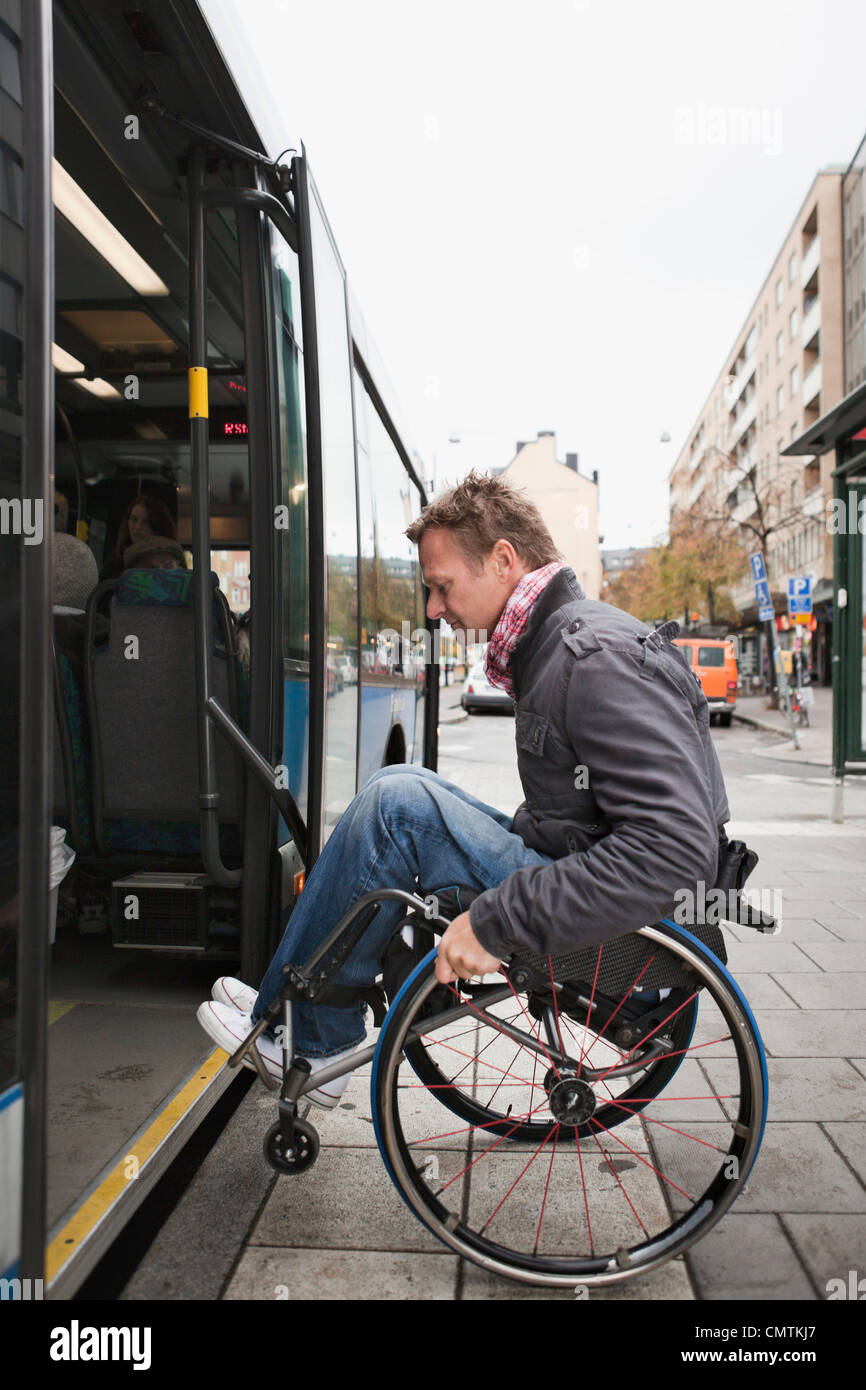 Mann im Rollstuhl in den Bus Rollen Stockfoto