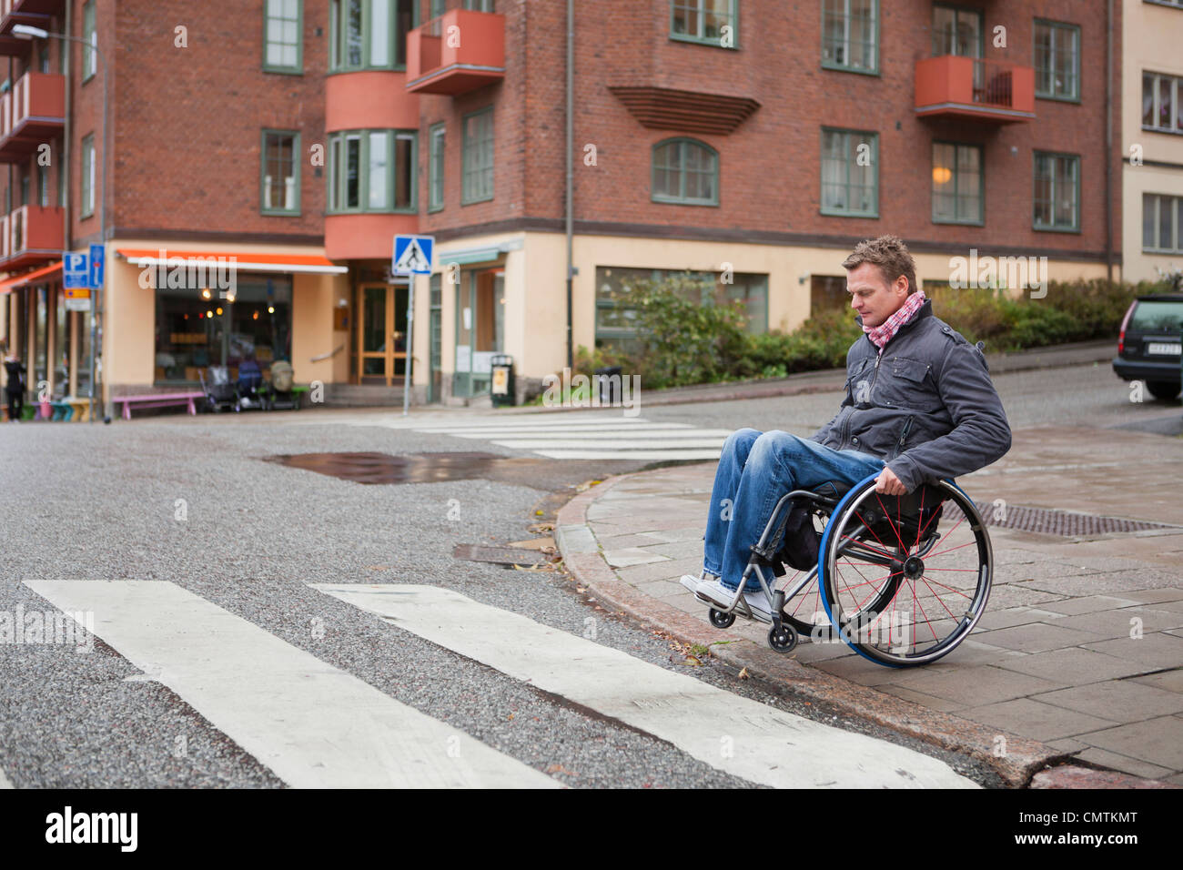 Mann im Rollstuhl Kreuzung Straße Stockfoto