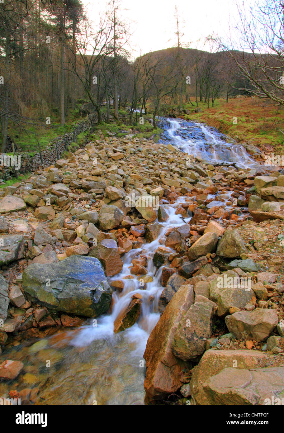 Wasser fließt durch Felsen in Buttermere-See in der Seenplatte, Cumbria, England UK Stockfoto