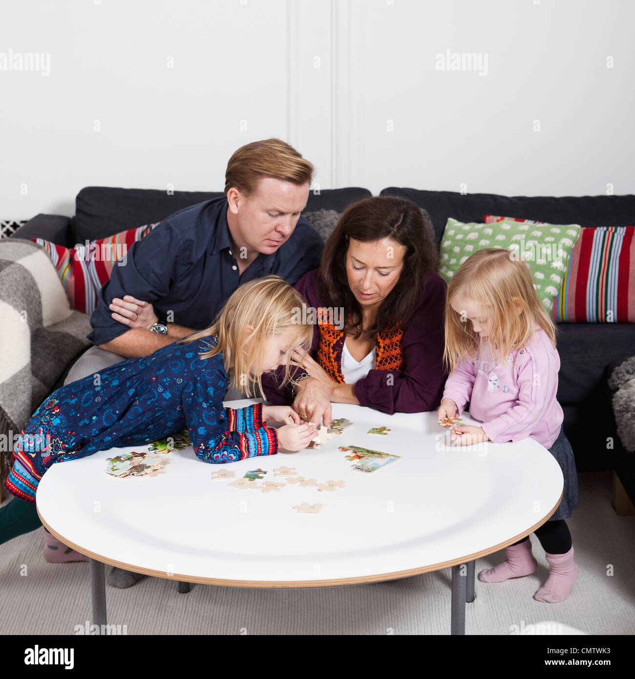 Familie mit zwei Kindern (2-4) spielen puzzle-Spiel Stockfoto