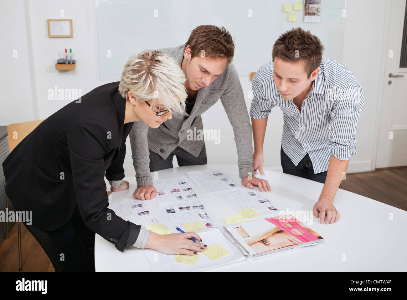 Drei Kollegen schreiben auf Papier Stockfoto