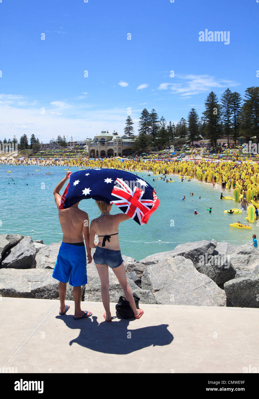 Ein Mann und eine Frau hält eine australische Flagge am Australia Day während der Havaianas-Hüpfburgen-Weltrekord Versuch Cottesloe Stockfoto