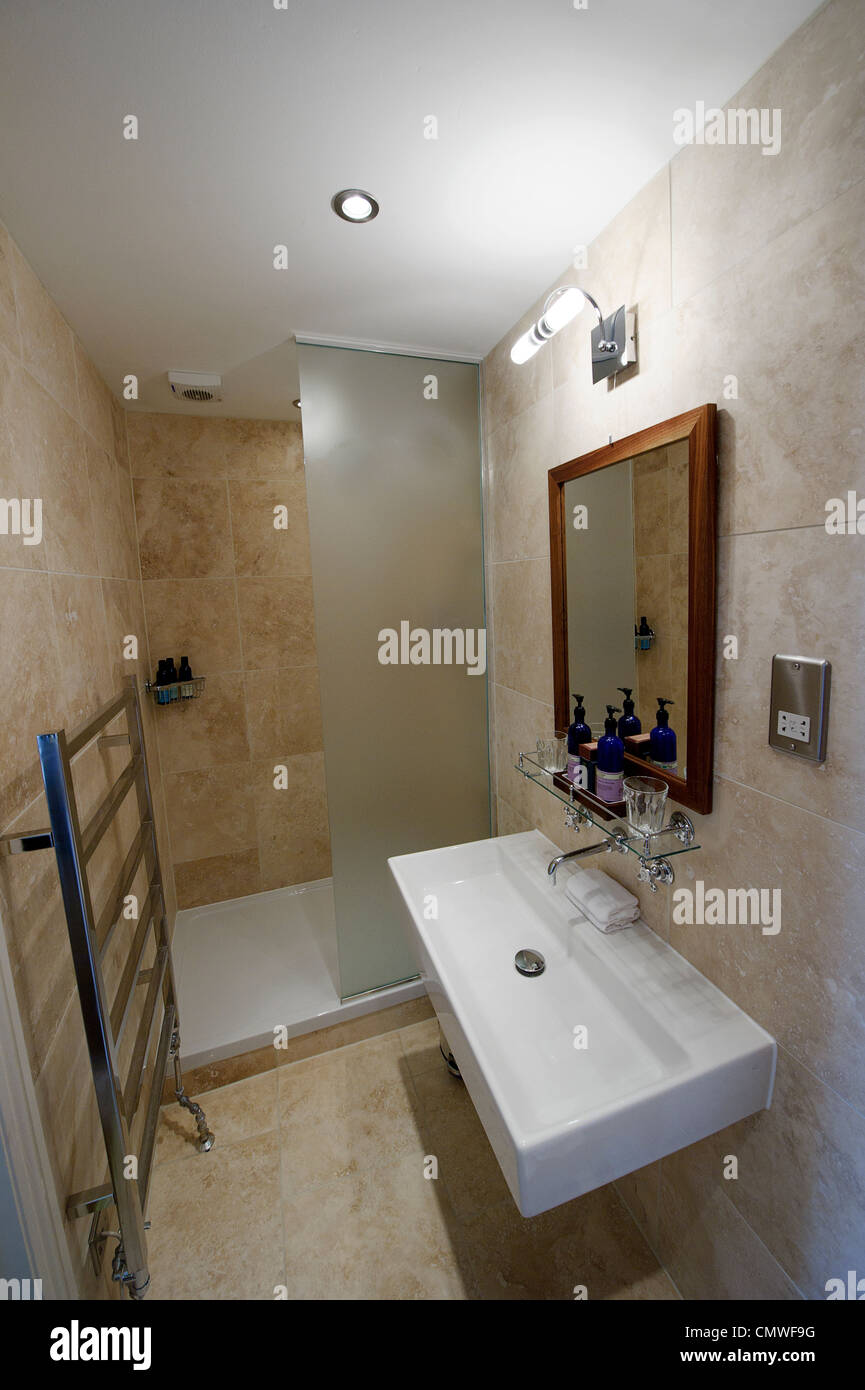 modernes kompakte Hotel zeigen Haus Bad Nasszelle mit länglichen Waschbecken,  Wand-Heizkörper und Dusche Stockfotografie - Alamy