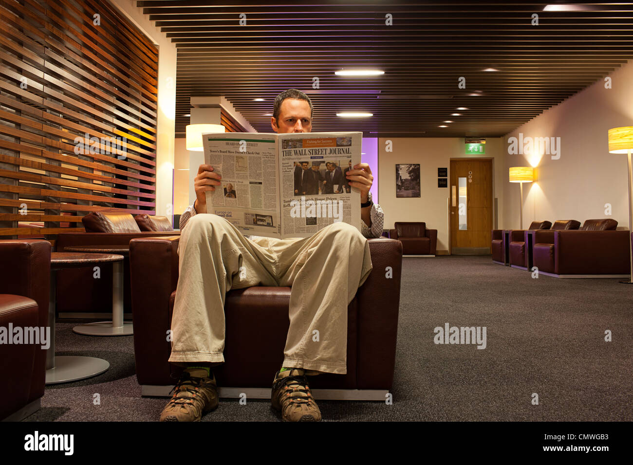 Mann liest Zeitung im Star Alliance Lounge Stockfoto