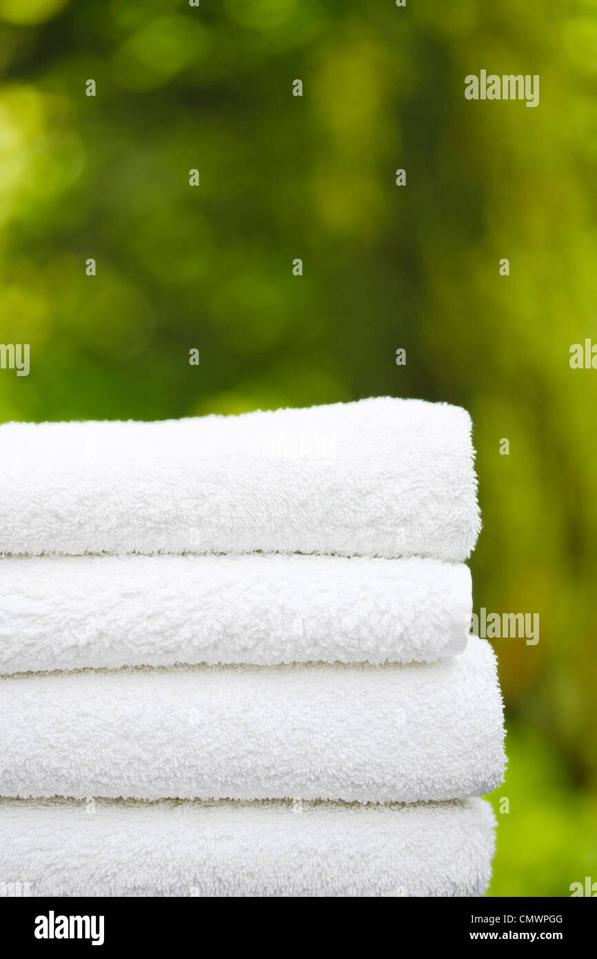 Stapel von weißen Handtücher in einer Gartenanlage mit Exemplar, ideal für die Darstellung von einem Day-Spa oder wellness Stockfoto