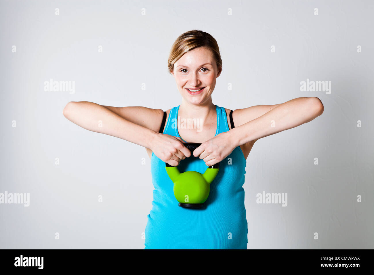 Schwangere Frau tun Schultermuskel Stärkung Übung mit der kettlebell Stockfoto
