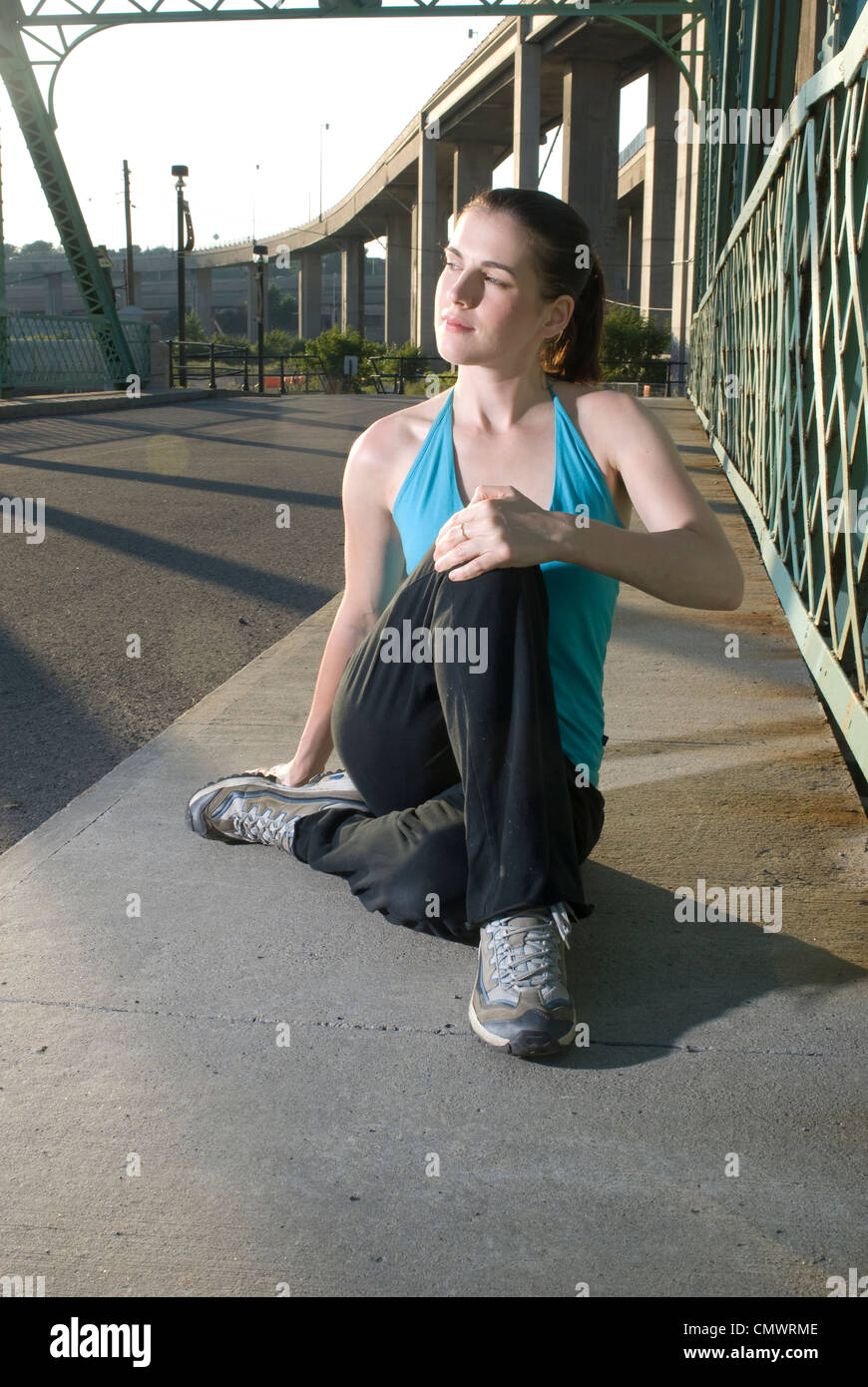 Sportler, die Streckung Knie vor dem Lauf, Lachine Canal, Montreal, Quebec Stockfoto