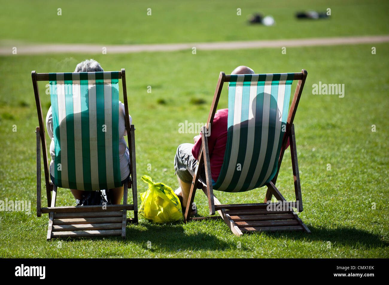 Zwei Personen genießen die Sonne im Hyde Park in London Stockfoto