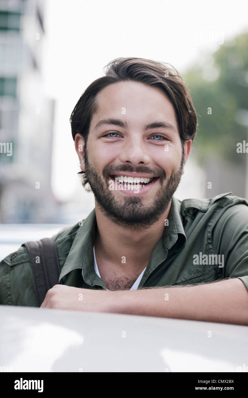 Deutschland, Köln, junger Mann in der Nähe von Auto, Lächeln, Porträt Stockfoto