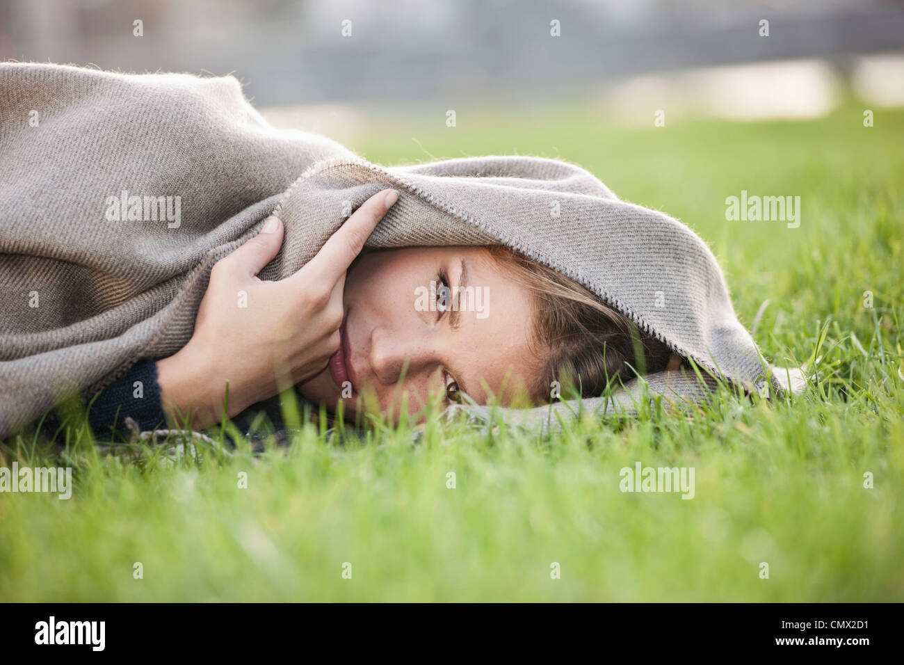 Deutschland, Köln, junge Frau liegt im Rasen, Porträt Stockfoto
