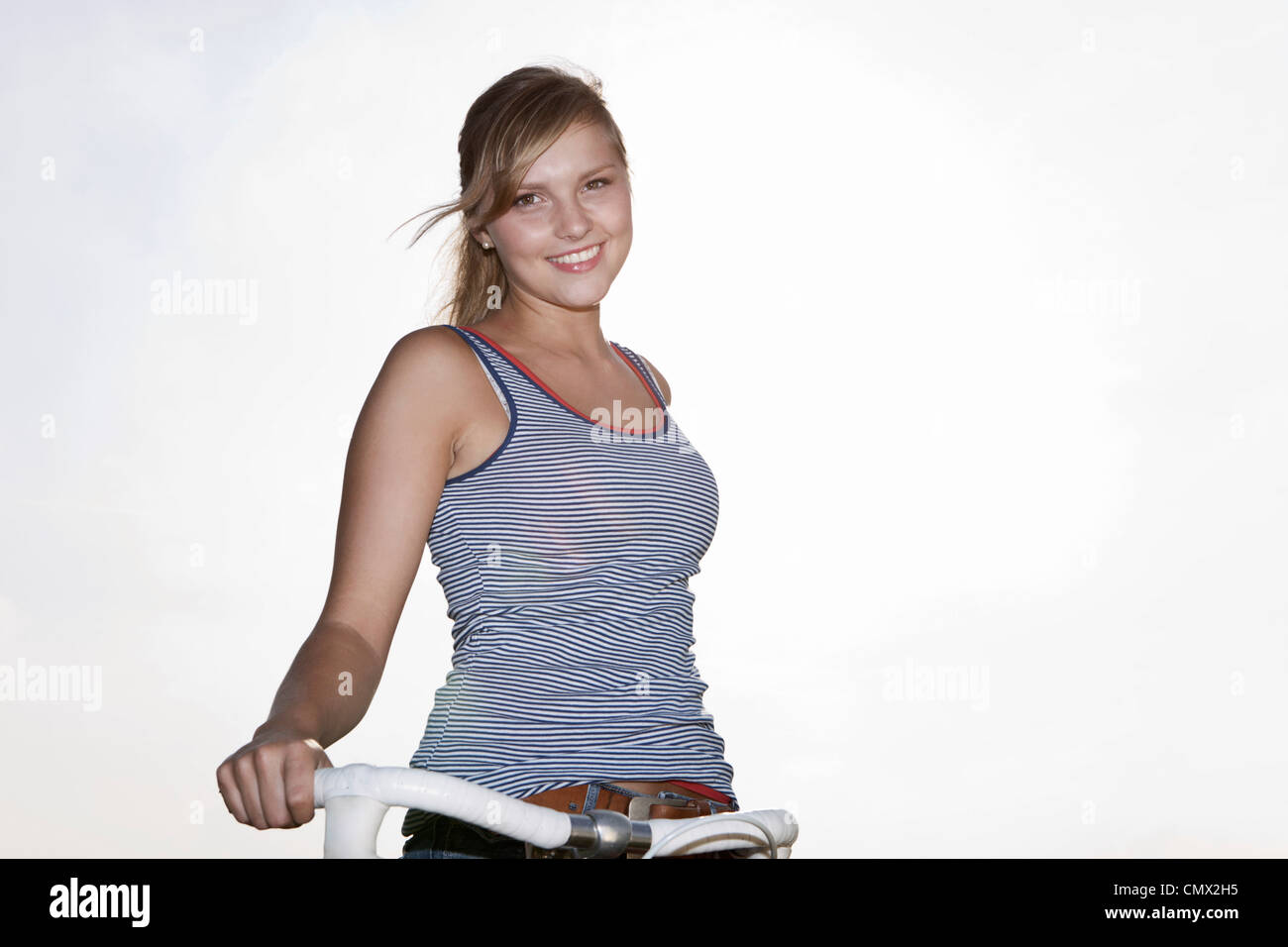 Deutschland, Köln, junge Frau mit dem Fahrrad, Lächeln, Porträt Stockfoto