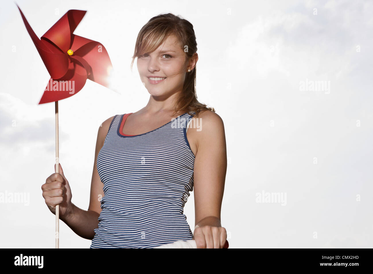 Deutschland, Köln, junge Frau mit Windrad, Lächeln, Porträt Stockfoto