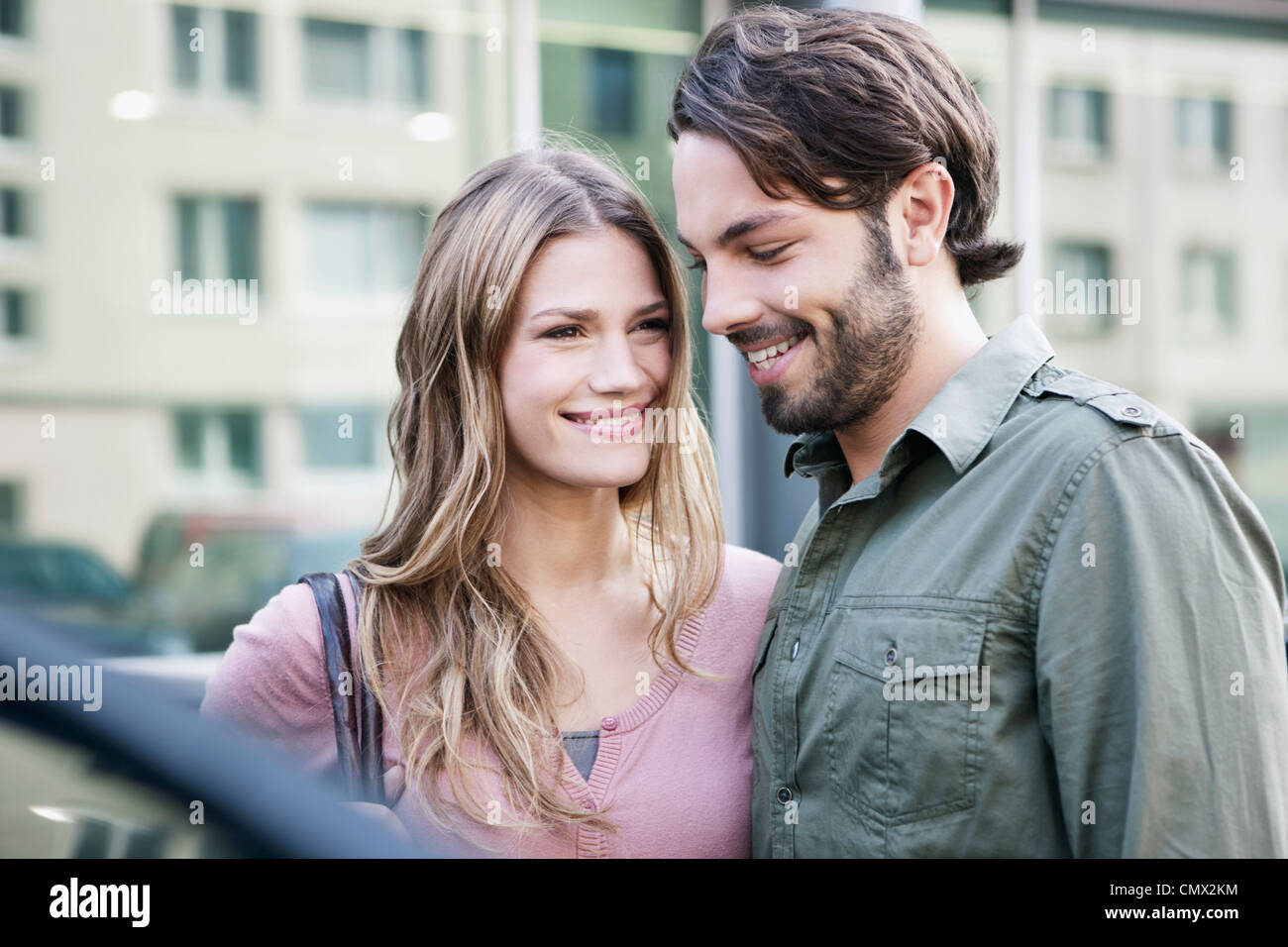 Deutschland, Köln, junges Paar in der Nähe von Auto, Lächeln Stockfoto