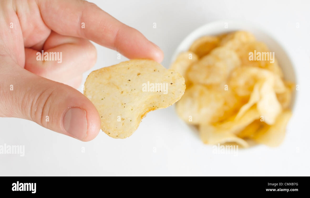 Hand mit Kartoffel-Chips Stockfoto