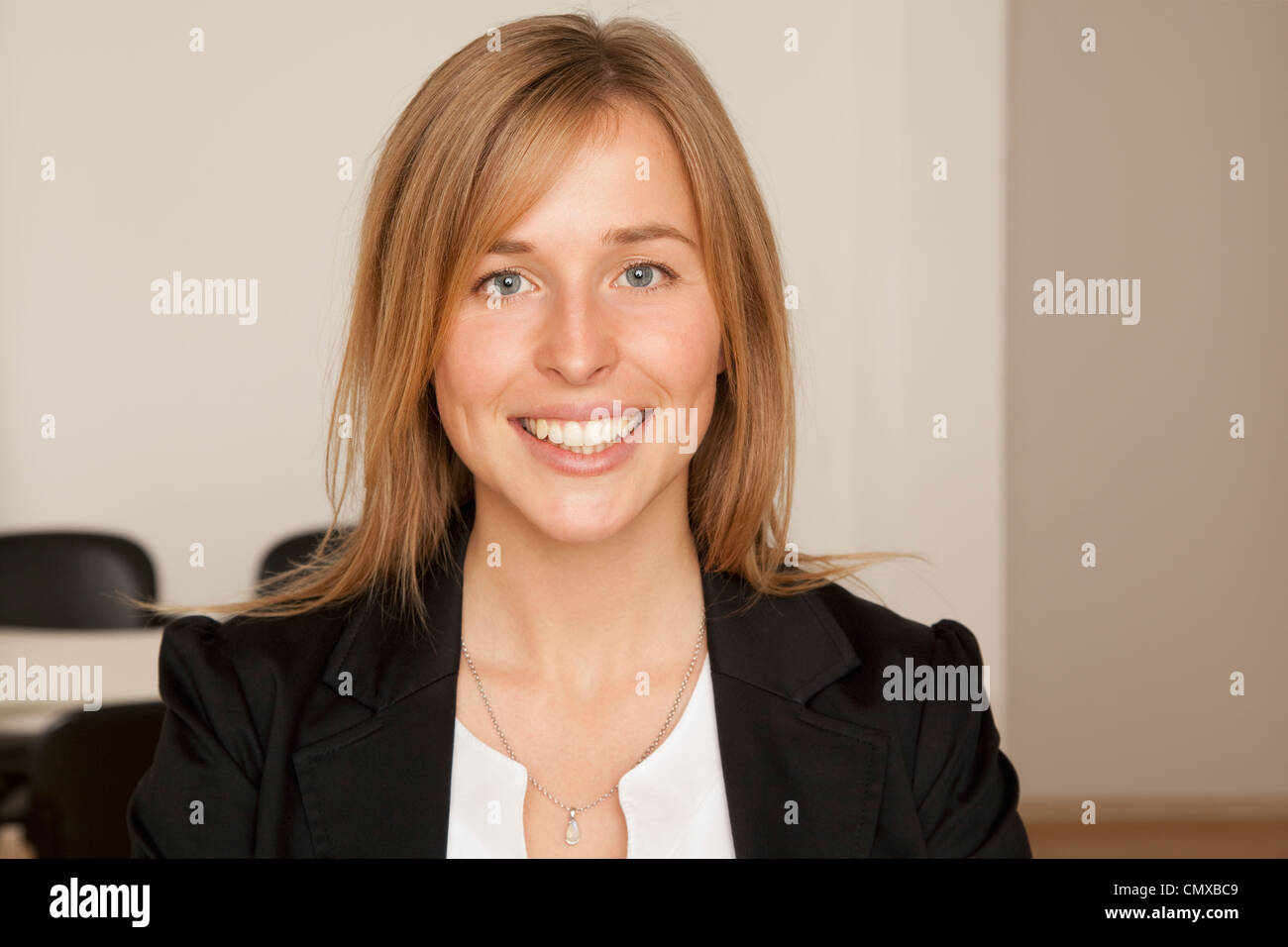 Junge Frau im Präsidium, Lächeln, Porträt Stockfoto