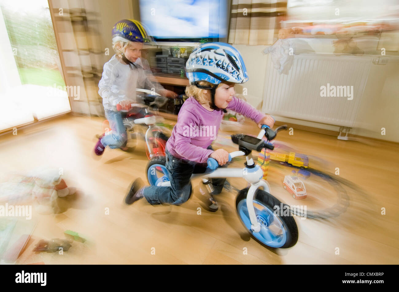 Deutschland, Bayern, Mädchen spielen mit dem Fahrrad im Wohnzimmer Stockfoto
