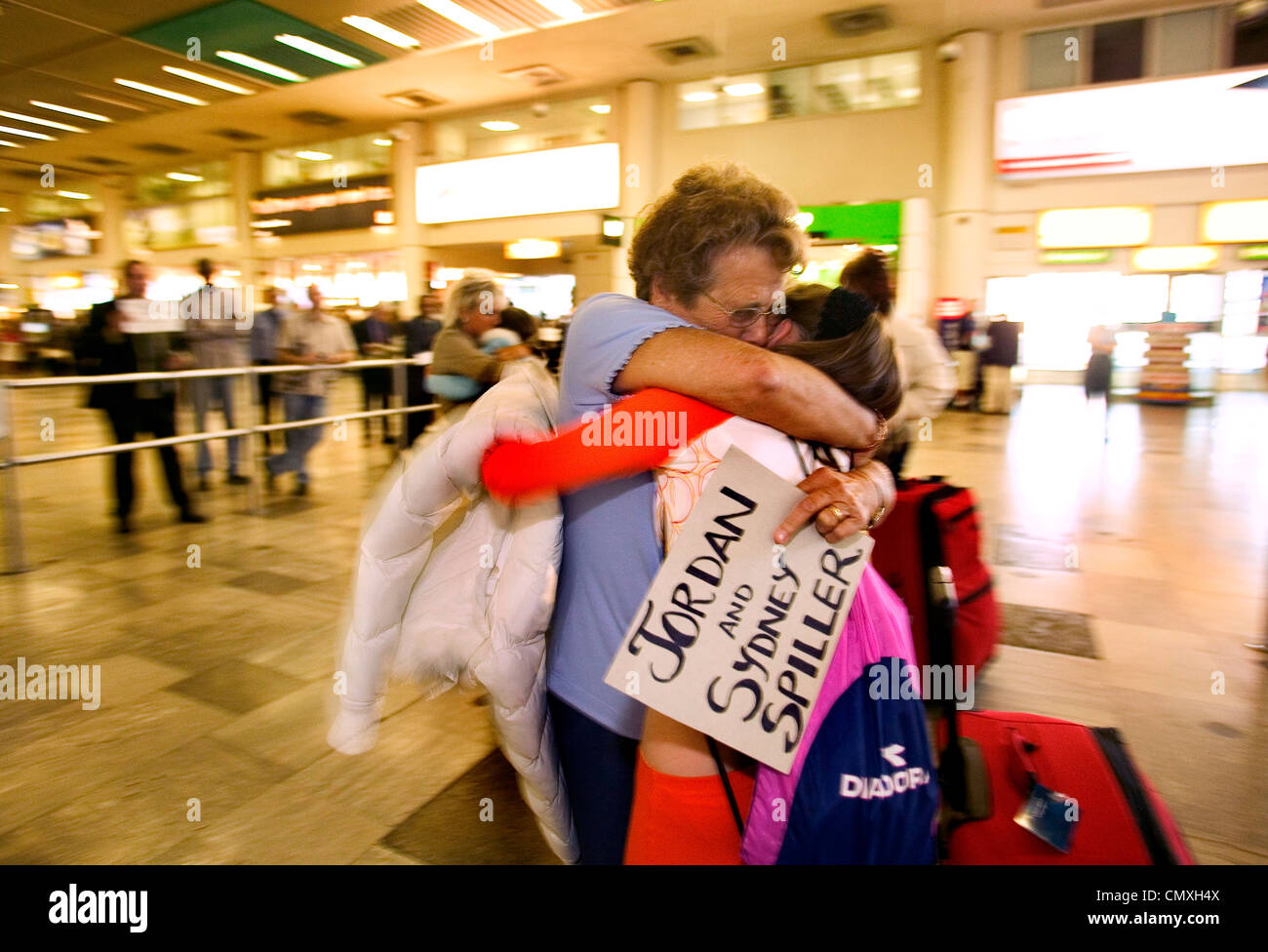 Familie wieder vereint in der Ankunftshalle am Flughafen Heathrow Stockfoto