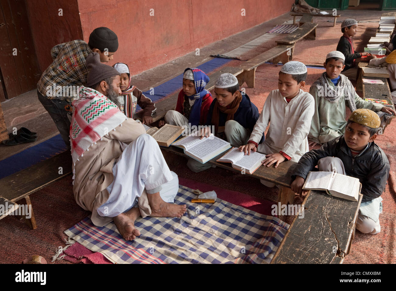 Agra, Indien. Schüler lernen, den Koran mit ihrem Imam zu lesen. Stockfoto