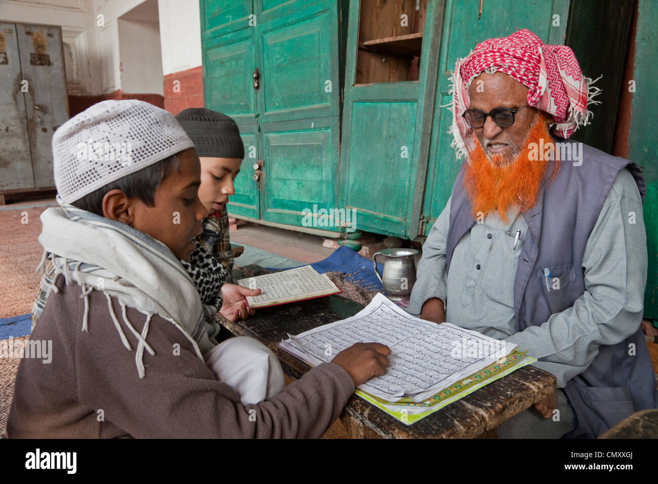 Agra, Indien. Schüler lernen, den Koran mit ihrem Imam zu lesen. Stockfoto