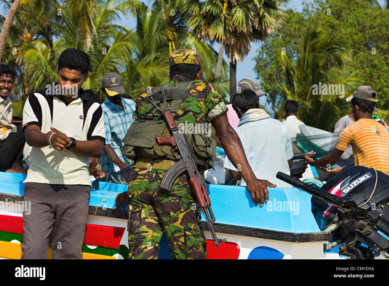 Fischer & Sri-lankischen Armee Soldat an diesem beliebten Surfstrand an der ehemals unruhigen Ostküste; Arugam Bay, Sri Lanka, Asien Stockfoto