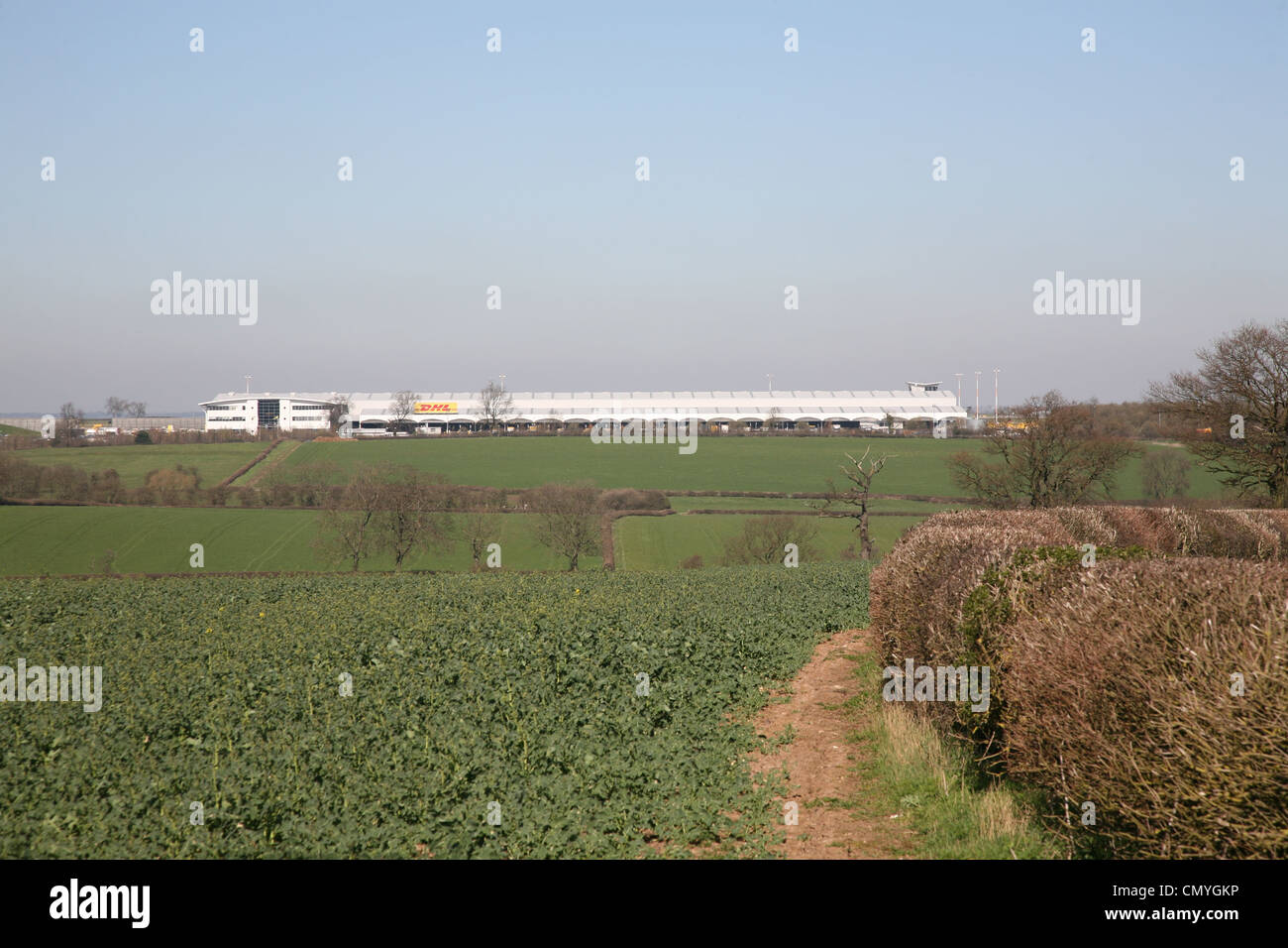 ein Blick über Felder mit der Dhl-Gebäude am East Midlands Airport in der Hintergrund-leicestershire Stockfoto